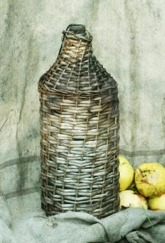 Royalty Free Photo of a Wicker Bottle and Apples