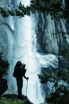 Royalty Free Photo of a Man Hiking Near a Waterfall in Yosemite National Park