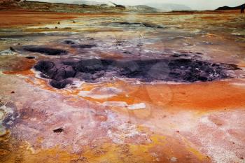 Boiling mud pools in a geothermal landscape in Iceland