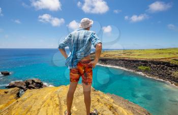 Tourist standing a top a cliff overlooking, Big island Hawaii's