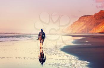 Man on ocean beach at sunset. Vacation concept background.