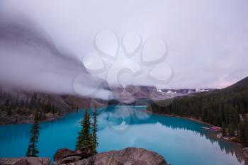 Beautiful turquoise waters of the Moraine lake with snow-covered peaks above it in Banff National Park of Canada