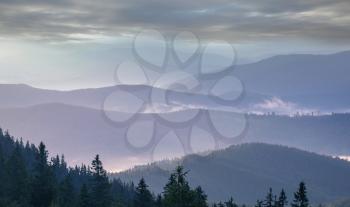 Misty mountain silhouette at sunrise