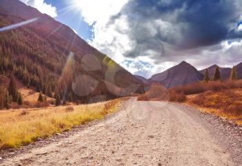 Colorful Autumn scene on countryside road in the sunny morning