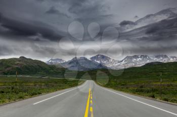 Scenic highway in Alaska, USA. Dramatic view storm clouds 