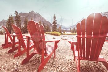 Red comfortable deck chairs on the lake in Canada. Canadian travel concept