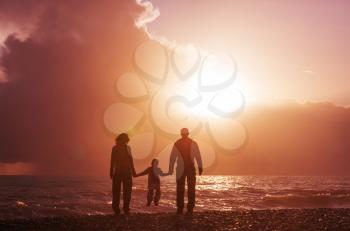 Family on the beach on sunset.