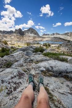 feet of a resting hiker against a mountain backdrop