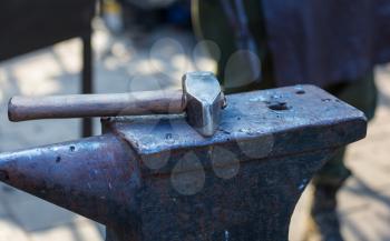 The blacksmith manually forging the molten metal on anvil