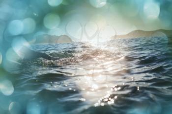 Blue wave on the beach. Blur background and sunlight spots. Peaceful natural background.