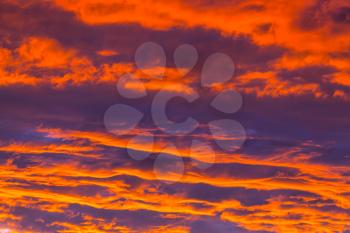 Unusual storm clouds at sunset. Bright red and orange colors of the sky. Suitable for background.