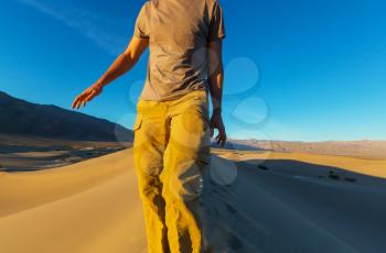 Hiker in sand desert. Sunrise time.