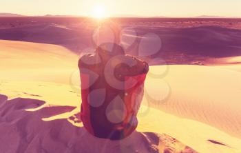 Hiker in sand desert. Sunrise time.