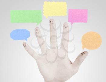 Happy group of finger smileys with social chat sign and speech thought. Fingers representing a social network.