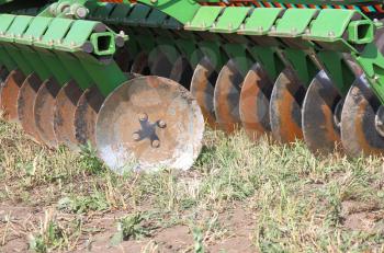 disc harrow behind tractor turning the soil 