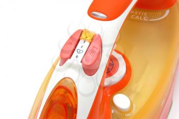 The electric iron it is white orange color with a white cord