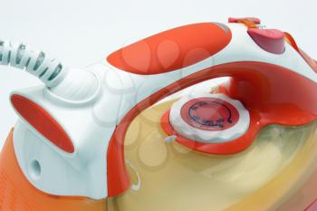 The electric iron it is white orange color with a white cord