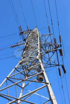 The high voltage post against the blue sky