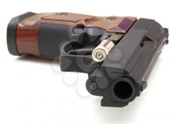 The close up of a pistol a target and cartridges is isolated on a white background