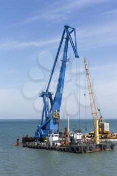 crane barge doing marine heavy lift installation works in the gulf or the sea.