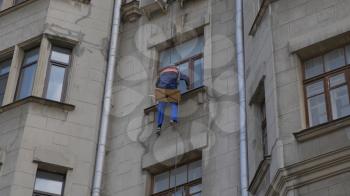 MOSCOW - AUGUST 26: Climber spends repair work on a multi-storey building height on August 26, 2017 in Moscow, Russia.