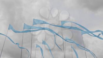 Blue flags fluttering in the wind, against a background of green grass.