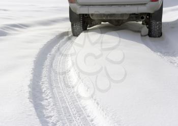 Snowy winter road behind an unrecognizable car