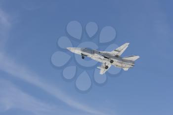 Military jet bomber Su-24 Fencer flying above ground.