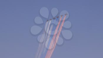 stormtroopers planes Su-25 fly in sky leaving trail of smoke as tricolor Russian flag on training parade in honor of Great Patriotic War victory.