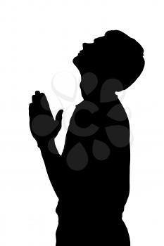 Side profile portrait silhouette of a religious teenage boy praying with raised head 