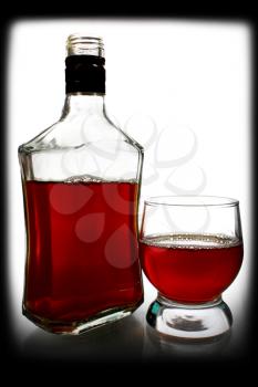 alcohol drink is in a bottle and glass on white background