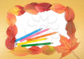 autumn leaves pencils and white sheet of paper