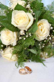 two gold wedding rings and bouquet