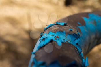 Old dark blue paint on a rusty pipe