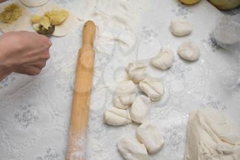 round shape of the dough and rolling pin with flour on the table 