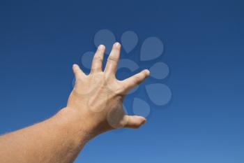 man's hand against the blue sky