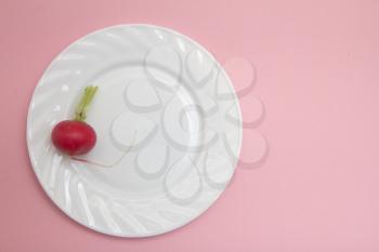 red radish in a bowl on a pink background