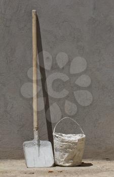 bucket and spade on a concrete wall background