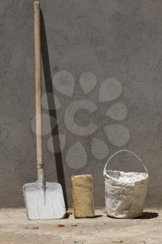 bucket and spade on a background of brick and concrete wall