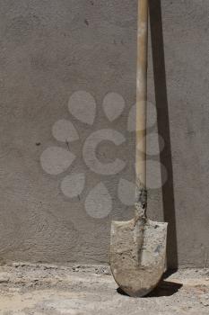 shovel against the concrete wall