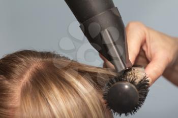 Hairdresser dries the hair in a beauty salon