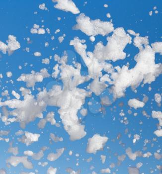 White foam against the blue sky as background .