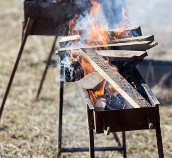 Firewood is burning in the grill in the open air