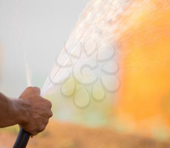 Man watering the lawn with a hose .