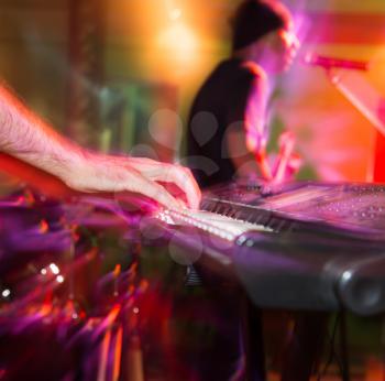 Musician plays keyboards in a rock band .