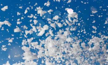 White foam against the blue sky as background .