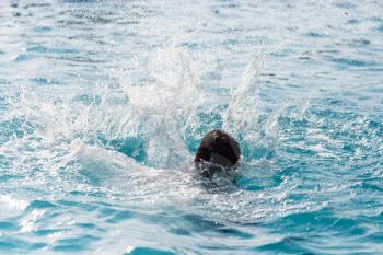 The boy is swimming in the pool