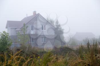 house cottage in the fog in the morning .