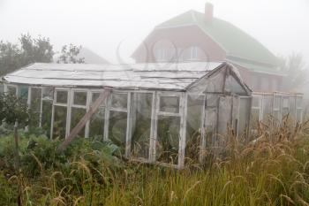 a hothouse in the fog in the morning .