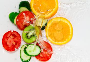 fresh fruits and vegetables in water on a white background